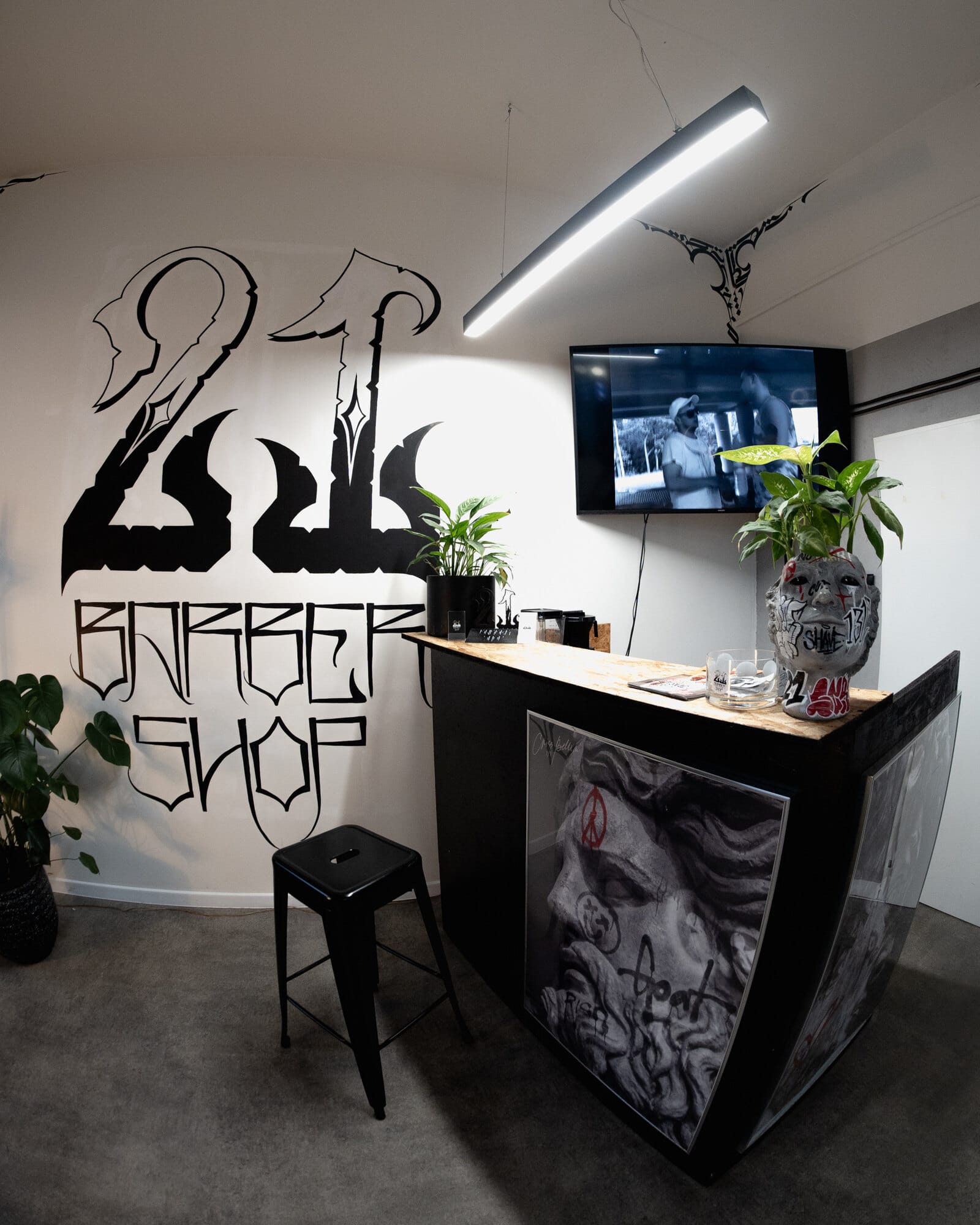 Wnętrze 21.BARBERSHOP z gotyckim logo na ścianie