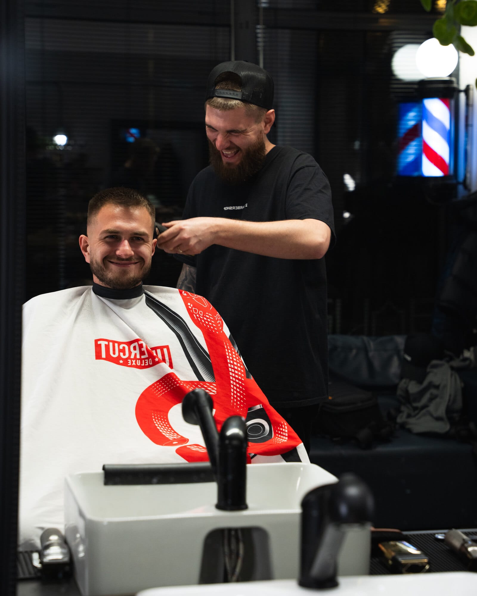 Barber wykańcza strzyżenie klienta